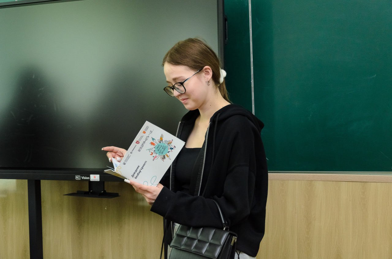 Студентка читає Довідник безбар'єрності